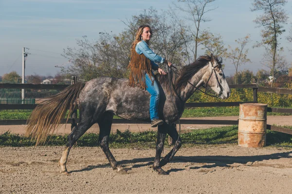 Mooi meisje rijdt haar grijs paard — Stockfoto