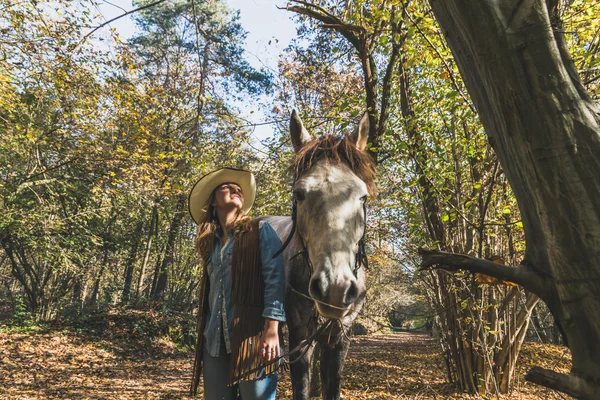 Söt flicka står vid hennes grå häst — Stockfoto