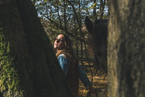 Pretty girl standing by her grey horse — Stock Photo, Image