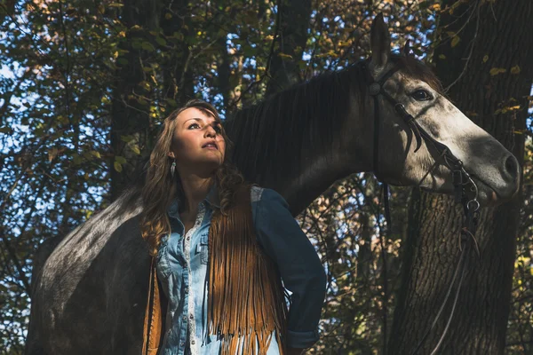 Menina bonita em pé por seu cavalo cinza — Fotografia de Stock