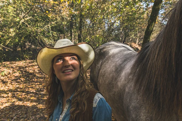 Söt flicka står vid hennes grå häst — Stockfoto