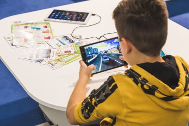 Child playing with tablet at G come giocare in Milan, Italy