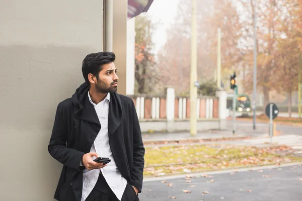 Bello indiano uomo sms in un contesto urbano — Foto Stock