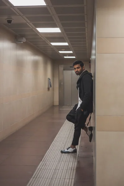 Handsome Indian man posing in a metro station — Stock Photo, Image