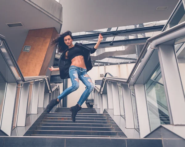 Beautiful girl jumping from a staircase — Stock Photo, Image