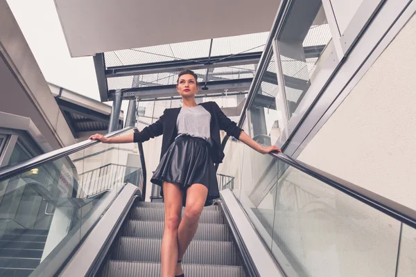 Beautiful girl posing on an escalator — Stock Photo, Image