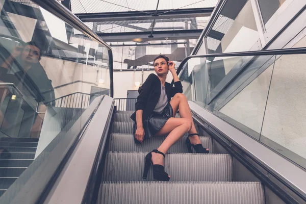 Menina bonita posando em uma escada rolante — Fotografia de Stock