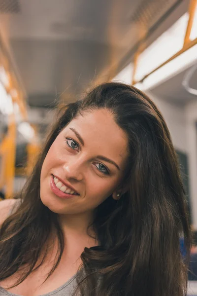 Hermosa chica con curvas posando en un coche de metro — Foto de Stock