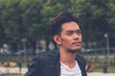 Yakışıklı Asya model şehir sokaklarını poz