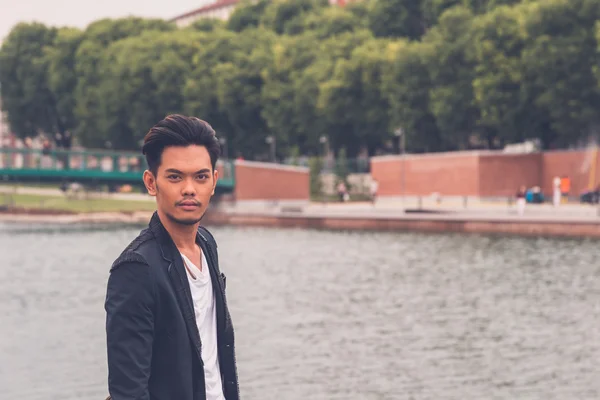 Handsome Asian model posing by an artificial basin — Stock Photo, Image