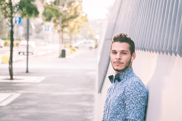 Joven hombre guapo escuchando música en las calles de la ciudad —  Fotos de Stock