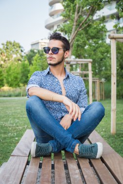 Yakışıklı delikanlı bir şehir parkında poz