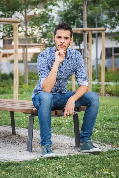 Молодой красивый мужчина позирует в городском парке — стоковое фото