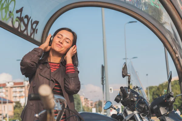 Bella ragazza che ascolta musica in un contesto urbano — Foto Stock