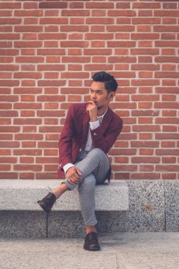 Şehir sokakta oturan yakışıklı Asya modeli