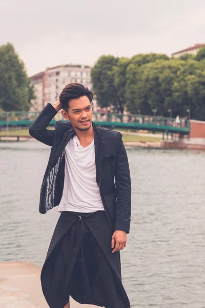 Handsome Asian model posing by an artificial basin — Stock Photo, Image