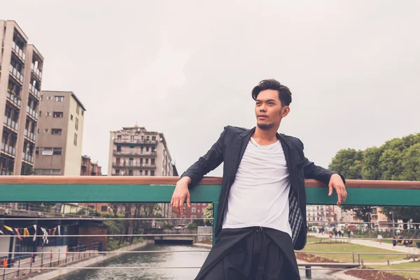 Handsome Asian model posing by an artificial basin — Stock Photo, Image