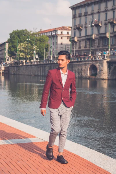 Handsome Asian model posing by an artificial basin — Stock Photo, Image