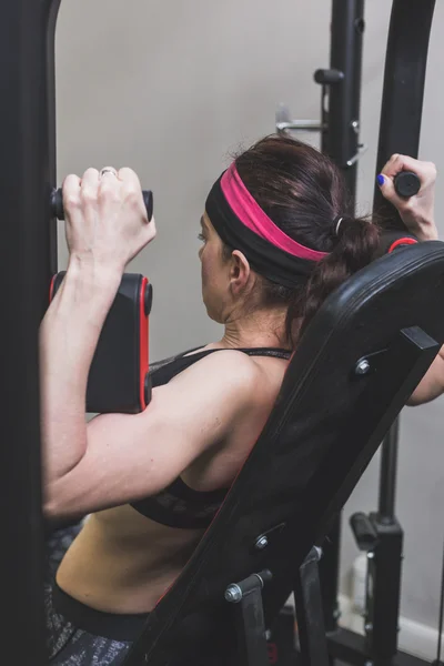 Vacker flicka träning i gymmet — Stockfoto