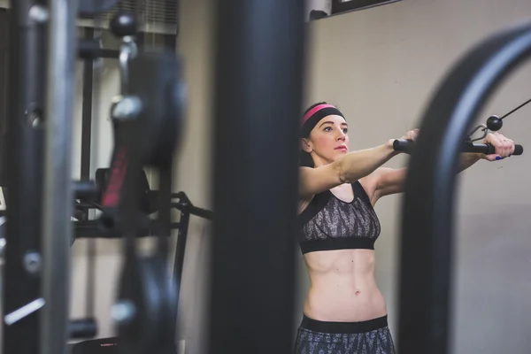 Hermosa chica haciendo ejercicio en el gimnasio — Foto de Stock