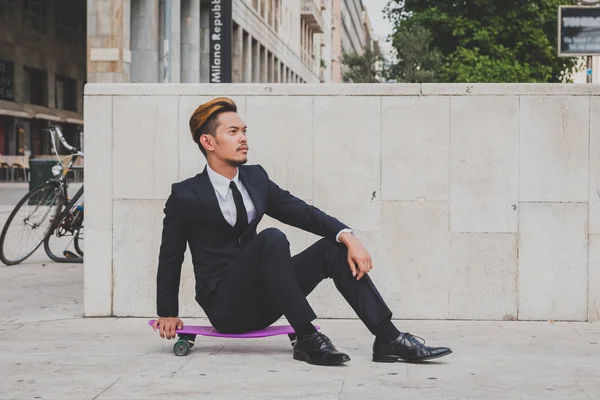 Junge hübsche asiatische Modell posiert mit seinem Skateboard — Stockfoto