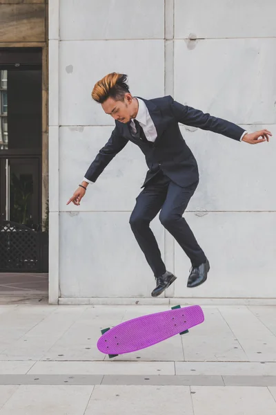 Young handsome Asian model jumping with his skateboard — Stock Photo, Image