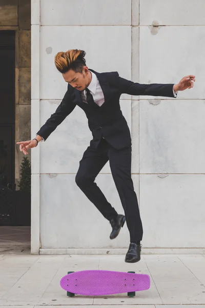 Young handsome Asian model jumping with his skateboard — Stock Photo, Image