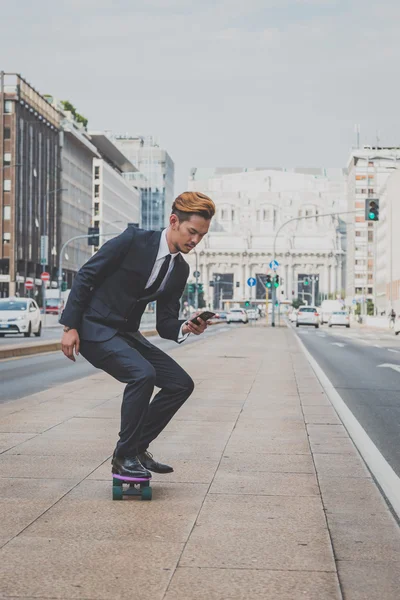 Young handsome Asian model riding his skateboard — Stock Photo, Image