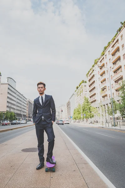 Young handsome Asian model posing with his skateboard — Stock Photo, Image