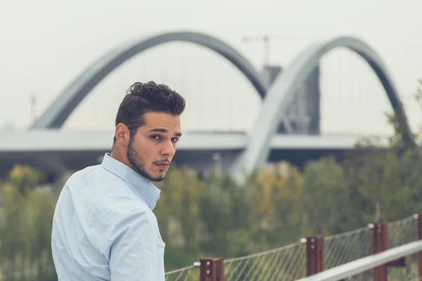 Joven hombre guapo posando en un contexto urbano — Foto de Stock