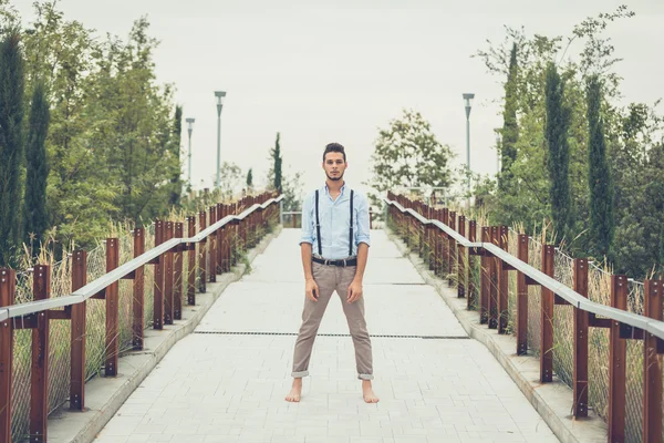 Joven hombre guapo posando en un contexto urbano — Foto de Stock