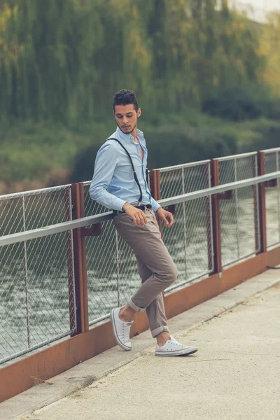 Joven hombre guapo posando en un contexto urbano — Foto de Stock