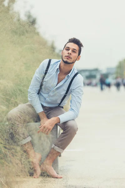 Joven hombre guapo posando en un contexto urbano — Foto de Stock