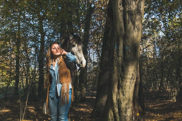 Jolie fille debout près de son cheval gris — Photo