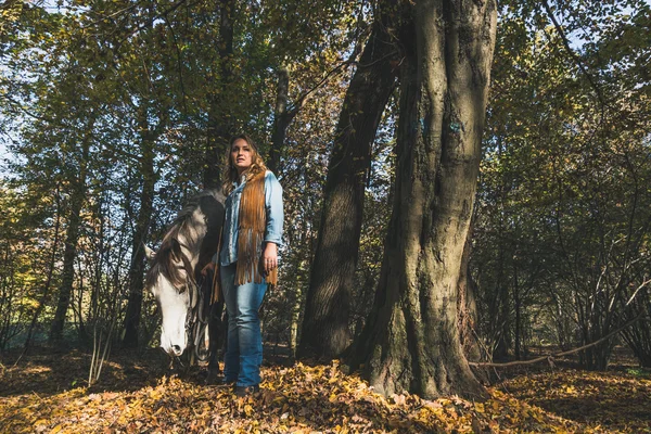 Jolie fille debout près de son cheval gris — Photo