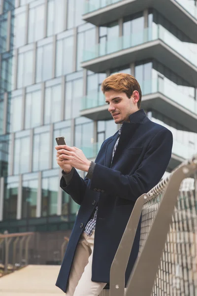 Giovane uomo sms per le strade della città — Foto Stock