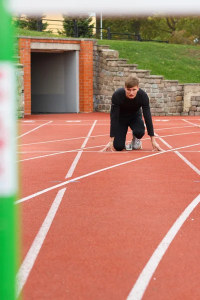 Portrait of sexy muscle man in low start on stadium — Stock Photo, Image