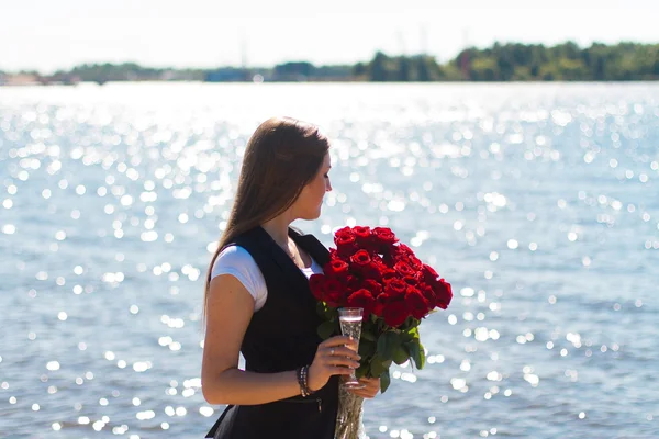 Obrázek sexy žena, že otráví na moři se sklem a růže — Stock fotografie