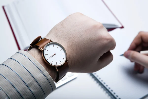 Empresario del lugar de trabajo mira el reloj — Foto de Stock