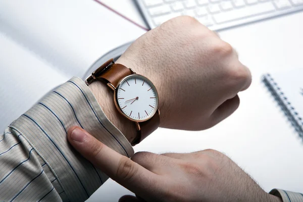 Workplace businessman looks at the clock — Stock Photo, Image