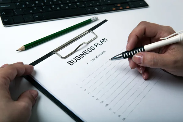 Businesswoman filling business plan — Stock Photo, Image