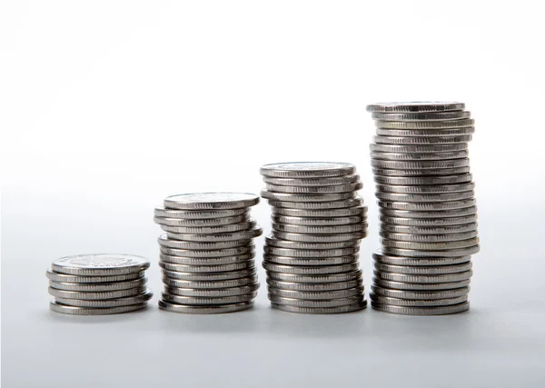 Montones de monedas sobre un fondo blanco — Foto de Stock