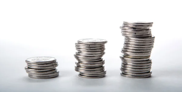 Stapels munten op een witte achtergrond — Stockfoto