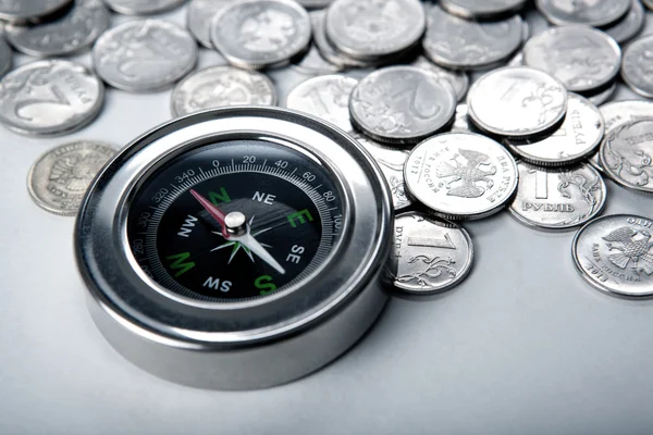 Pile of coins with compass — Stock Photo, Image