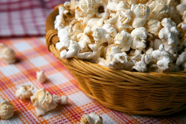 Gezouten popcorn in een rieten mand op een servet — Stockfoto