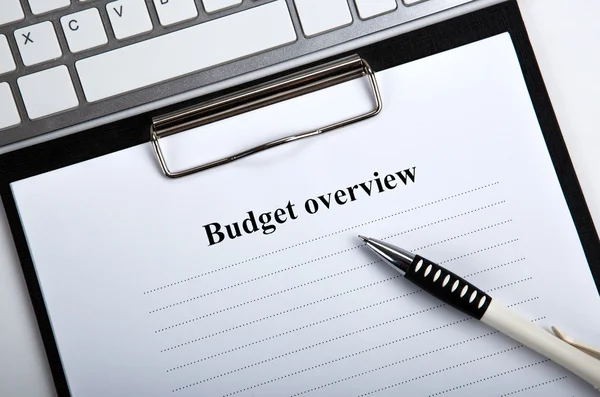Документ с обзором бюджета заголовка и клавиатурой — стоковое фото