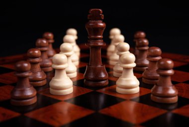 Satranç piyonları ve papaz siyah arka planda bir tahtada yakın plan