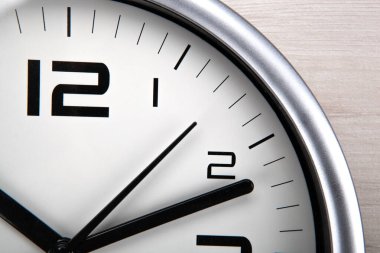 Ahşap zemin üzerinde rakamlar olan büyük beyaz saat yüzü