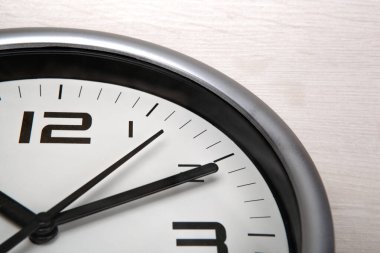 Ahşap zemin üzerinde rakamlar olan büyük beyaz saat yüzü