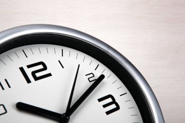 Ahşap zemin üzerinde rakamlar olan büyük beyaz saat yüzü